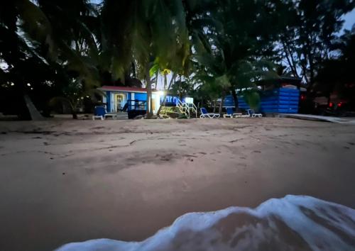 a beach with chairs and a house in the background at Dove Escapes - beach front One bdrm Cabana in Riversdale