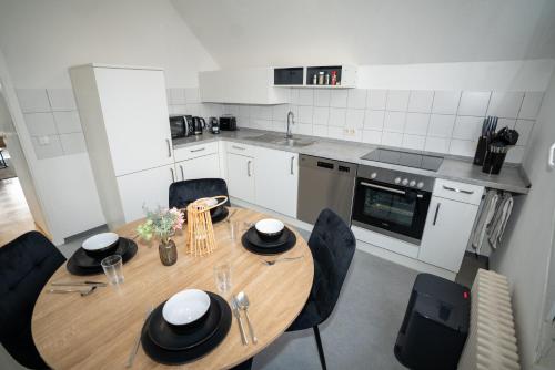 a kitchen with a wooden table and black chairs at Feel like Home 4 in Biberach an der Riß