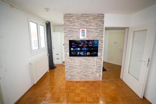 a room with a brick wall with a television on it at Feel like Home 4 in Biberach an der Riß