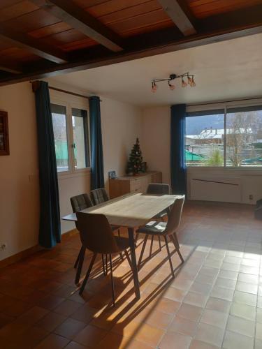 une salle à manger avec une table et des chaises en bois dans l'établissement Charmant T2 spacieux au pied de Montdauphin, à Eygliers