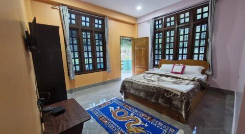 a bedroom with a bed and two windows at Dorey Homestay in Dirang Dzong