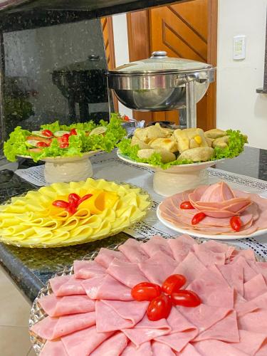 a buffet with plates of food on a table at Bombinhas Praia Apart Hotel - unidade rua Bem Te Vi in Bombinhas