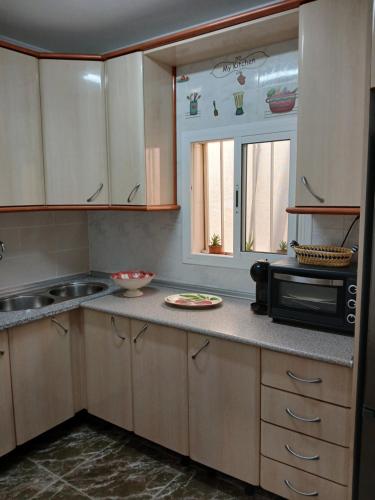 a kitchen with a microwave oven and a sink at La casita salinera in El Pozo del Cabo