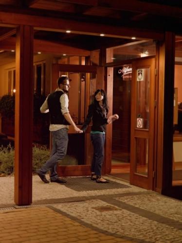 a man and a woman standing outside of a building at Hotel Na Skarpie - Charzykowy in Charzykowy