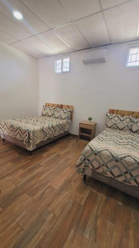 a room with two beds and a wooden floor at Apartamentos Mundo Maya in Flores