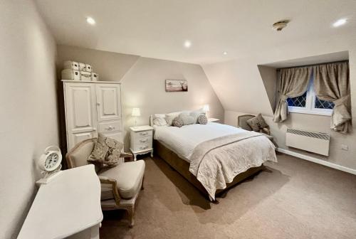 a bedroom with a bed and a chair and a window at Park Farm in Windsor