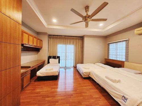 a bedroom with two beds and a ceiling fan at ipoh 5min to town centre 92bungalow 5br5bath19pax in Ipoh