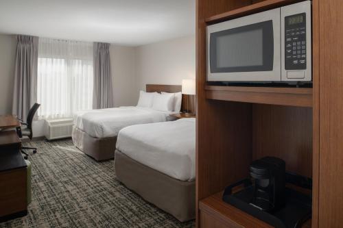 a hotel room with two beds and a microwave at Fairfield Inn & Suites by Marriott Tampa Westshore/Airport in Tampa
