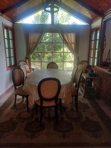 a dining room with a table and chairs and a window at PARCELA en MELIPILLA in Melipilla