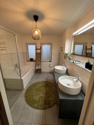 a bathroom with two sinks and a shower and a tub at La Dolce Vita Apartment in Kehl am Rhein