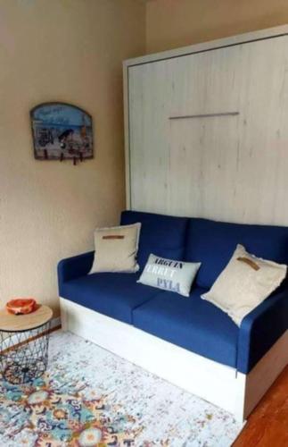 un canapé bleu avec deux oreillers dessus dans une pièce dans l'établissement Appartement Arcachon, à Arcachon