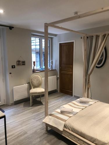 une chambre avec un lit, une chaise et une fenêtre dans l'établissement La montagnarde, à Huelgoat