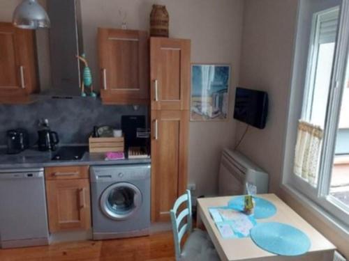 une cuisine avec une table et une machine à laver dans l'établissement Appartement Arcachon, à Arcachon