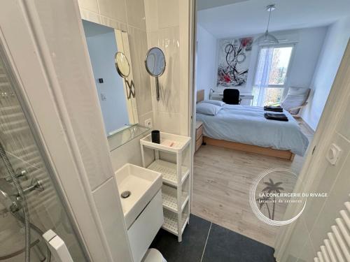 - une petite salle de bains avec un lit et un miroir dans l'établissement L'Horizon - Piscine - À 50m de la plage, à Hyères