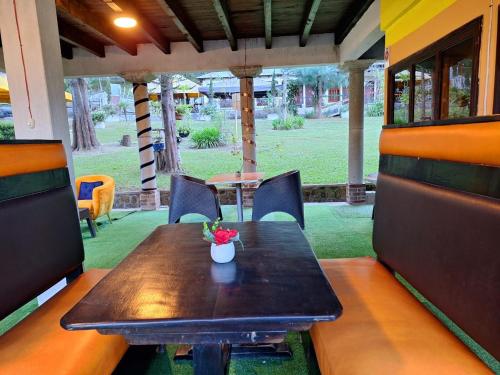 a wooden table with a vase of flowers on it at Hotel Casa Tecpán in Pamanzana