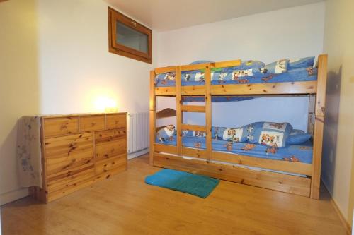 - une chambre avec des lits superposés et une commode dans l'établissement Appartement 7 personnes, Samoëns, à Samoëns
