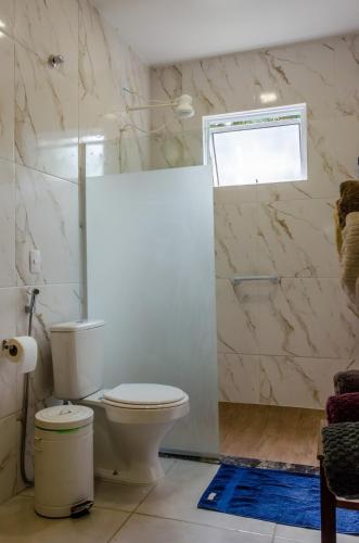 a white bathroom with a toilet and a shower at Loft - Vila São José in Araras Petropolis
