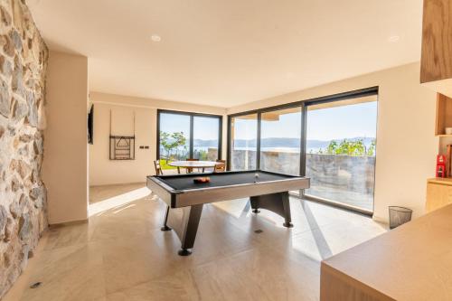 a house with a pool table in a room with windows at Casa Ambar Villa in San Juan Cosalá