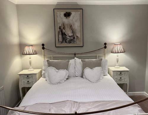 a bedroom with a white bed with two lamps at Park Farm in Windsor