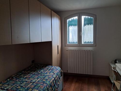 a bedroom with a bed and two windows at Barbara's House - Liguria in Santo Stefano al Mare