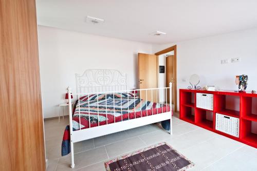 a bedroom with a white bed and red shelves at Cherry House in Minturno