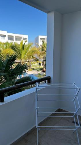 a bench on the side of a building with palm trees at Departamento a 5 min de la playa, Cerritos in Mazatlán