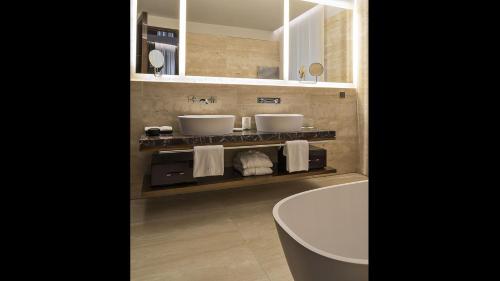 a bathroom with two sinks and a toilet and a tub at Fendi Private Suites - Small Luxury Hotels of the World in Rome