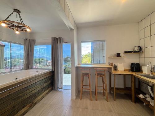 フロリアノポリスにあるApartamento Rio da Barra 2の浴槽、シンク、テーブルのあるキッチン