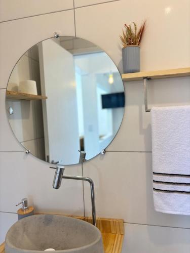 a bathroom with a sink and a mirror at Jacuzzi Privativa e Vista Mar - Apto Remo in Florianópolis