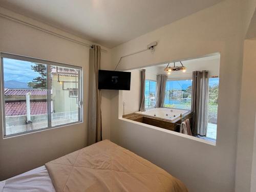 a bedroom with a bed and a tv and a pool table at Jacuzzi Privativa e Vista Mar - Apto Remo in Florianópolis