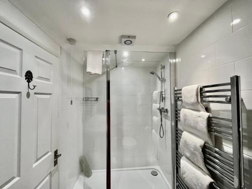 a white bathroom with a shower and a toilet at Park Farm in Windsor