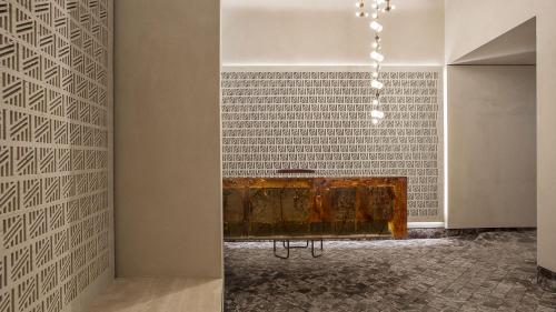 a room with a table and a wall at Fendi Private Suites - Small Luxury Hotels of the World in Rome