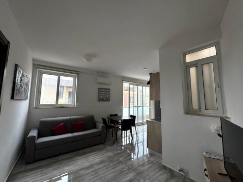 a living room with a couch and a table at Steps from Three Cities 2BR Apt in Il-Wileġ