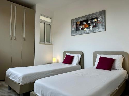 two beds sitting next to each other in a room at Steps from Three Cities 2BR Apt in Il-Wileġ
