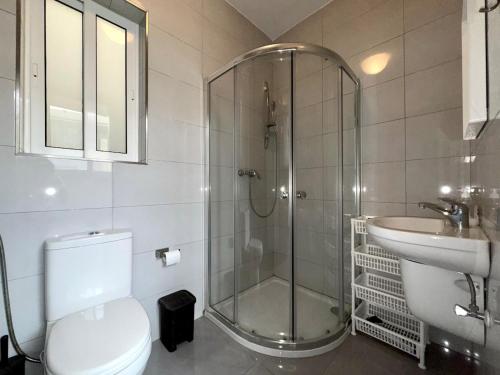 a bathroom with a shower and a toilet and a sink at Steps from Three Cities 2BR Apt in Il-Wileġ