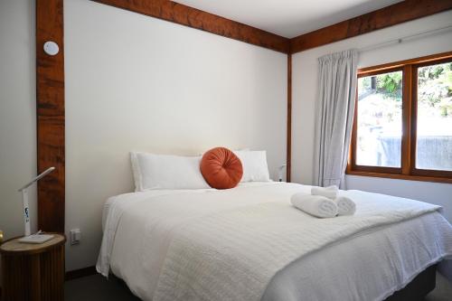 a bedroom with a white bed with towels on it at Muirs Reef Lodge Kinloch holiday home Lake Taupo in Kinloch
