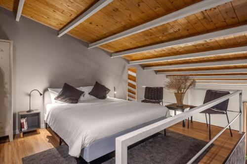 a bedroom with a white bed and wooden ceilings at Studio OF in Leonforte
