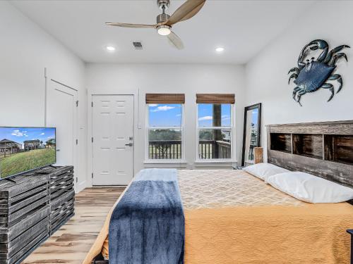 Un dormitorio con una cama grande y un televisor de pantalla plana. en Nautical Nest, en Rockport