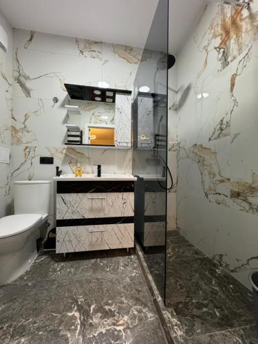 a bathroom with a toilet and a glass shower at Nice apartment in Chişinău