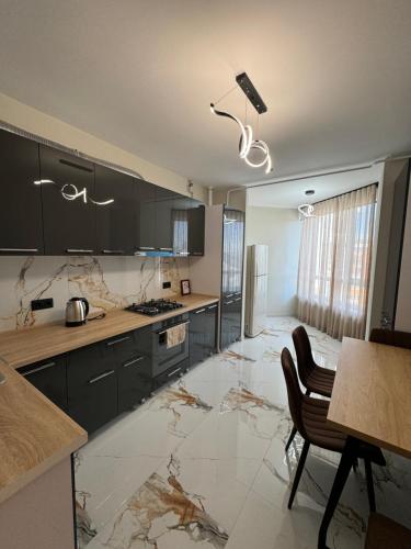 una cucina con mobili neri e pavimento in marmo di Nice apartment a Chişinău
