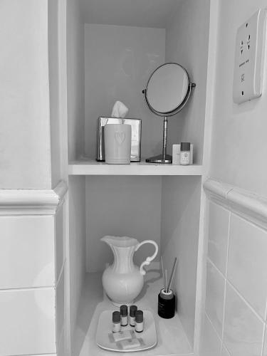 a shelf with a mirror and a vase and cosmetics at Park Farm in Windsor