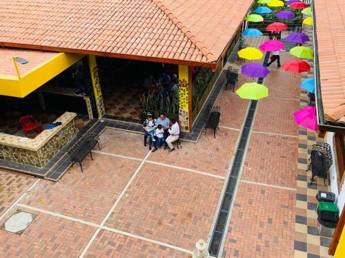 a group of people sitting in front of a building with umbrellas at ocobos club campestre in Tibirita