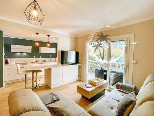 un salon avec un canapé et une cuisine dans l'établissement Le California - Port de Carqueiranne et plages, à Carqueiranne