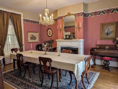 una sala da pranzo con tavolo e pianoforte di Historic Home with Southern Charm a Bristol