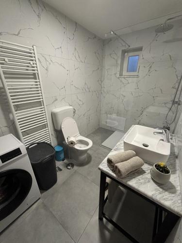 a white bathroom with a sink and a toilet at Villa Zgodić in Lovran