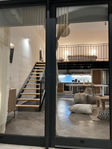 a view of a living room with a staircase through a window at Evas Urban loft 1 CLOSE TO PYTHAGOREIO in Chóra