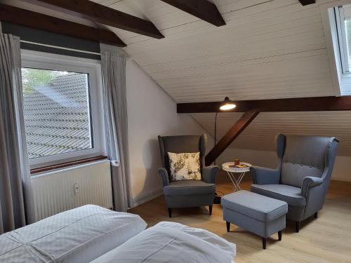 a bedroom with two chairs and a bed and a window at Klaus Huus in Böhl
