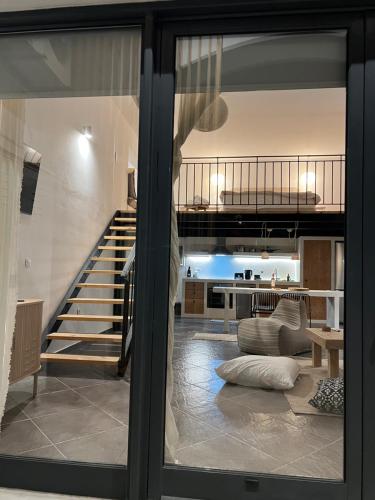a view of a living room and a staircase through a glass door at Evas Urban loft 1 CLOSE TO PYTHAGOREIO in Chóra