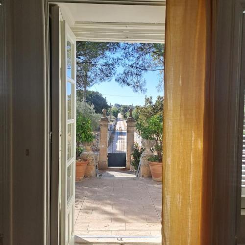 an open door with a view of a courtyard at Villa Quartarella - La bellezza nel silenzio - piscina in Michelica