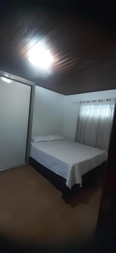 a bed in a room with a light on the ceiling at Lunar in Palhoça